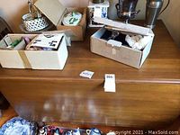 Wooden drop leaf table surface with boxes on top demonstrating size and condition