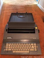 Front and top view of the Smith-Corona Spell-Right II typewriter with keyboard, paper holder, and brand/model labels.