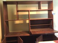 Photo of the mid-century modern styled cabinet with multiple shelves, an open compartment, and a fold-down drawer surface.