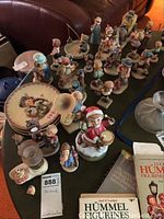 Assorted Hummel figurines and plate on tabletop