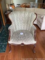 Front view of chair showing full upholstery pattern and carved wood frame
