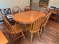 Full view of oval table set with six chairs in room