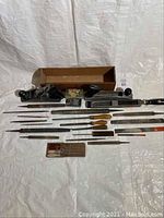 Full view of the planer, razor plane blade box, and multiple rasps and files arranged on a white backdrop.