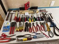 Full overview of all hand tools laid out showing hammers, screwdrivers, shears, pliers, scissors, rivet kit and cutters.