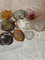 Overview of 11 assorted serving bowls and dishes of various materials and colors photographed under white backdrop.