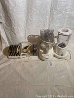 Full lot showing Cuisinart food processor with discs and Sunbeam blender side by side