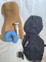 All four items shown together: Obus Form seat back, blue neck pillow, handheld massage wand, black massaging seat cushion with remote and adapter