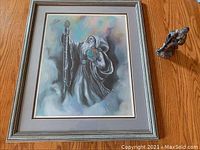 Framed wizard print and pewter figurine displayed side by side showing scale and overall appearance