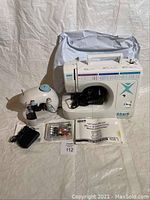 Photo showing Shark 605 sewing machine with foot pedal, instruction manual, colorful thread set, and carrying case