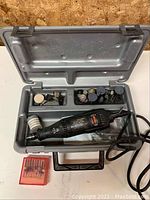 Open gray hard plastic case with Craftsman rotary tool and various accessories inside, plus a red case with fine drill bits to the left of the case. Photo shows contents and setup.