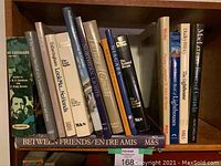 Front view of the 16 Canadiana books on shelf, titles visible