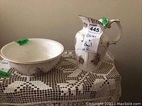 Photo showing the pitcher and bowl side by side on a lace cloth, highlighting their size and matching floral patterns.