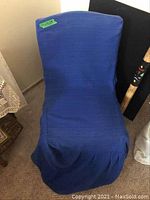 Blue fabric chair cover fitted over chair's back and seat, obscuring base and legs.
