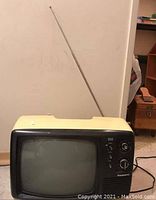 Front angled view of vintage Panasonic black and white TV showing antenna and control knobs.