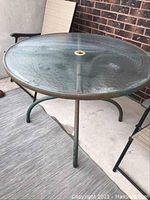 Top view of round tempered glass tabletop showing textured hammered glass and central umbrella hole.