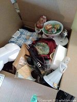 Box contents showing figurine, Easter eggs, dish cloths, massager, hand painted rock, and metal box.