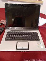 Front view of the HP Pavilion dv6000 laptop open, showing keyboard, touchpad, and screen.