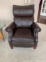 Front view of brown leather recliner showing padded back, seat and rolled arms