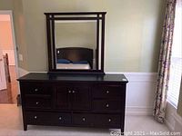 Full front view of the dark wood dresser with attached mirror, showing drawer arrangement and mirror size.