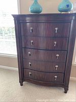 Full front view of cherry finish dresser showing five drawers and decorative hardware