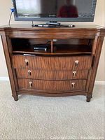 Front view of the media chest showing three drawers and two open shelves under a flat top surface.