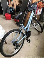 Rear angled view of the entire blue Roadmaster mountain bike showing the frame, seat, handlebar, and tires