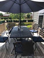 Full set on deck including table, six chairs with cushions, umbrella