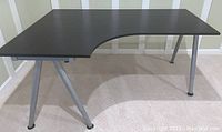 Full view of dark brown IKEA Galant corner desk showing curved inner corner and silver metal legs.