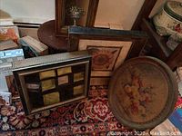 Full view of the tea chest, foot stool, decorative box, and framed wall art showing the items on a patterned red rug.