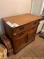 Full front and angled view of wood cabinet showing drawers and cabinet doors