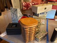 Overview of various storage boxes including basket-style box and decorative fabric covered boxes stacked