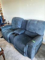 Front and side view of dual blue La-Z-Boy recliner sofa with padded arms and back cushions, displaying its two recliners and central console with cup holders.