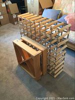 Photo showing solid wood rack with diagonal supports alongside a larger wood and metal rack for wine bottles.