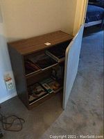 Photo of the wooden modern bookshelf with several books inside, positioned against a wall