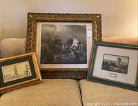 Wide photo showing all three framed wall arts on sofa, varying sizes and frame styles.