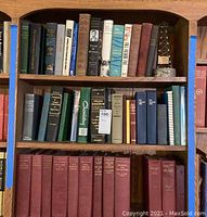 Books on wooden shelves including titles such as 'Team of Rivals' and others, and a metal figurine shaped like an oil derrick.
