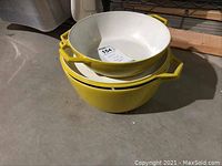 Stacked three-piece set of yellow and white Copco Denmark enamel cast iron cookware with hexagonal handles.