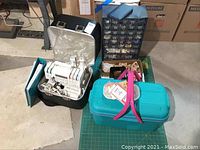 Overall lot on basement floor: serger, organizers, cutting mat, boxes