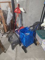 View of mop with bucket, broom, and black toolbox step stool near wall.