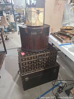 Four stacked decorative storage items with various styles and sizes in basement setting