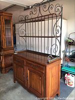 Full view of the sideboard with decorative metal rack on top, showing wooden drawers and cabinet doors.
