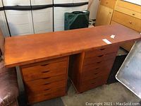 Full view of wooden plank desktop placed on top of the two rolling cabinets, showing reddish-brown finish and visible surface scratches.