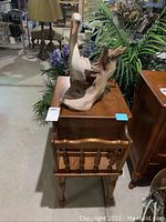 Overall view of vintage magazine rack with carved wooden heron on top, showing wood grain and style