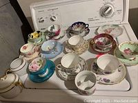 Overhead shot of assorted cups and saucers displayed on washing machine