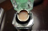 Top view of the brooch back showing pin clasp and unreadable hallmarks.