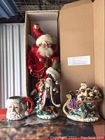Set of Fitz & Floyd Christmas figurines and mug in original box with lid open, items arranged upright.