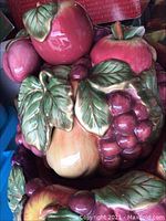 Close-up of ceramic fruit and leaf detail on tureen lid.