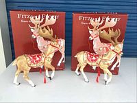 Front view of two deer figurines with original Fitz & Floyd Town & Country boxes behind.