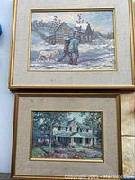 Photo of two paintings stacked vertically showing winter scene with people and dog, and house with garden.