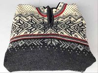 Folded view of sweater showing top collar and traditional Nordic pattern with zipper.
